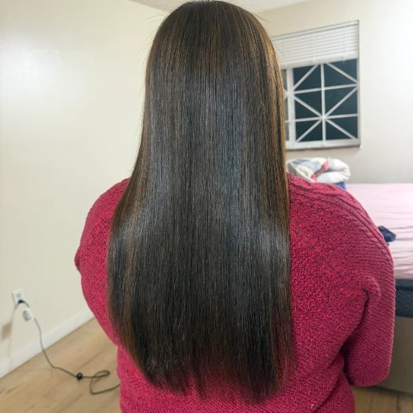 Long straight dark hair over a red sweater