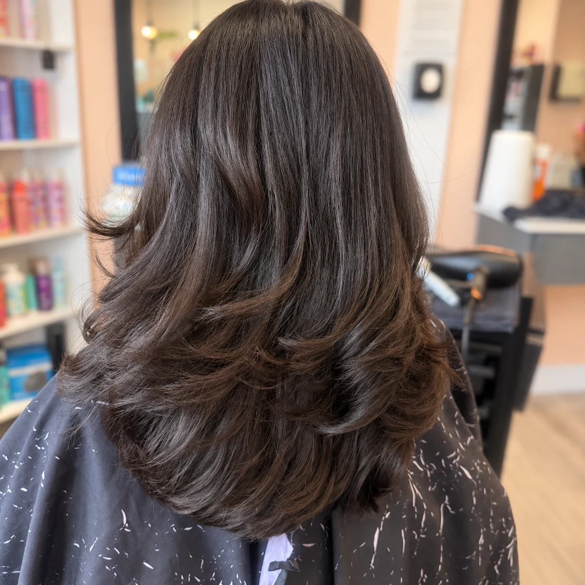 Rear view of a layered haircut with softly curled ends